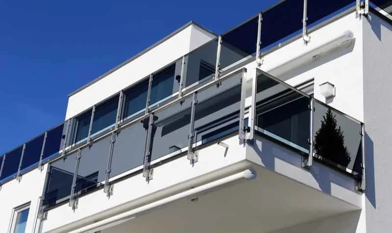 Balkongeländer aus Metall mit senkrechten Füllstäben an einem Wohnhaus