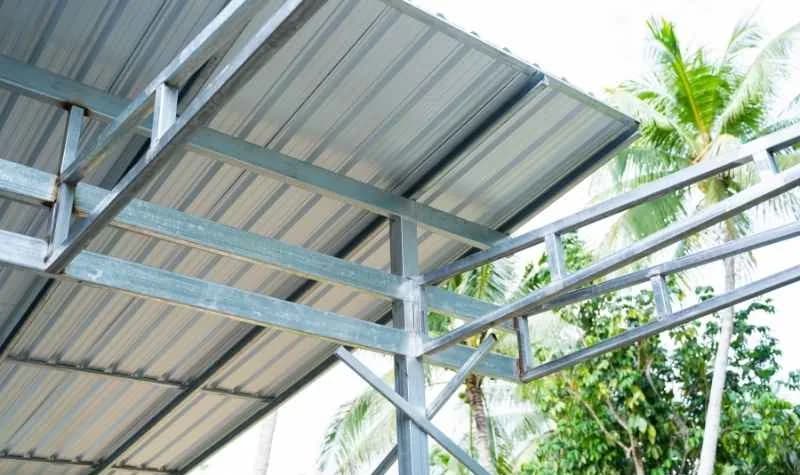 Terrassenüberdachung aus Metall mit Glasdach über einer Holzterrasse